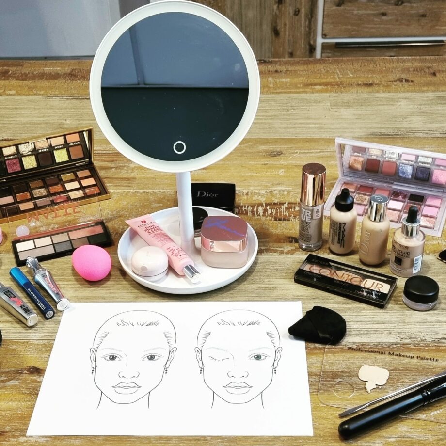 Makeup collection scattered across a wooden surface